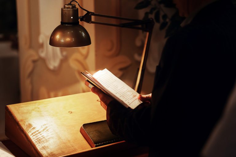 priest holding holy bible book and reading at wedding ceremony