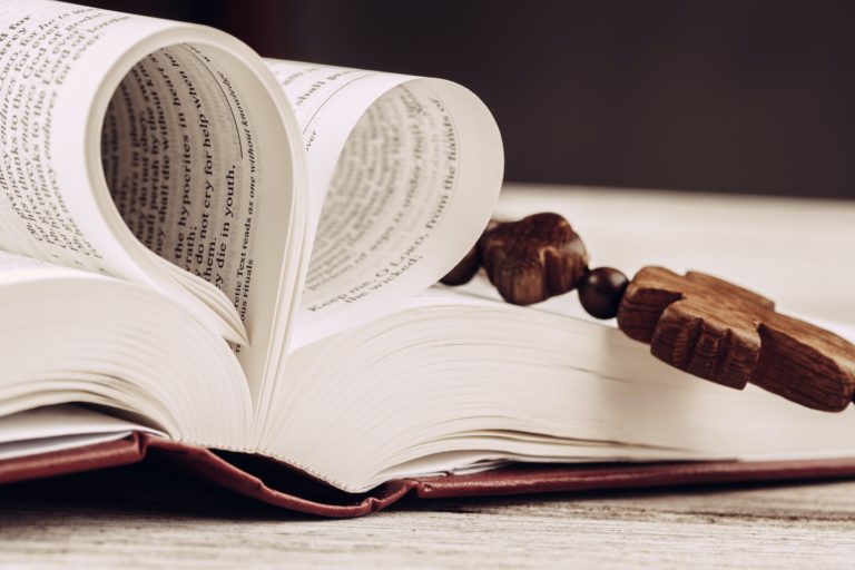 Bible and a crucifix on an old wooden table. Religion concept.