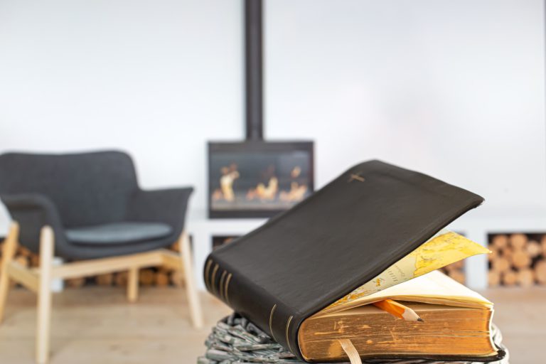 Bible book with pencil, on the background of the living room.