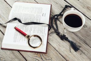 Bible and a crucifix on an old wooden table. Religion concept.